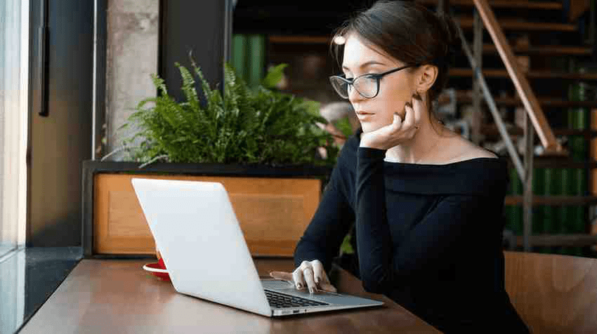 A medical school student studying for USMLE Step 1 on her laptop in a cafe.